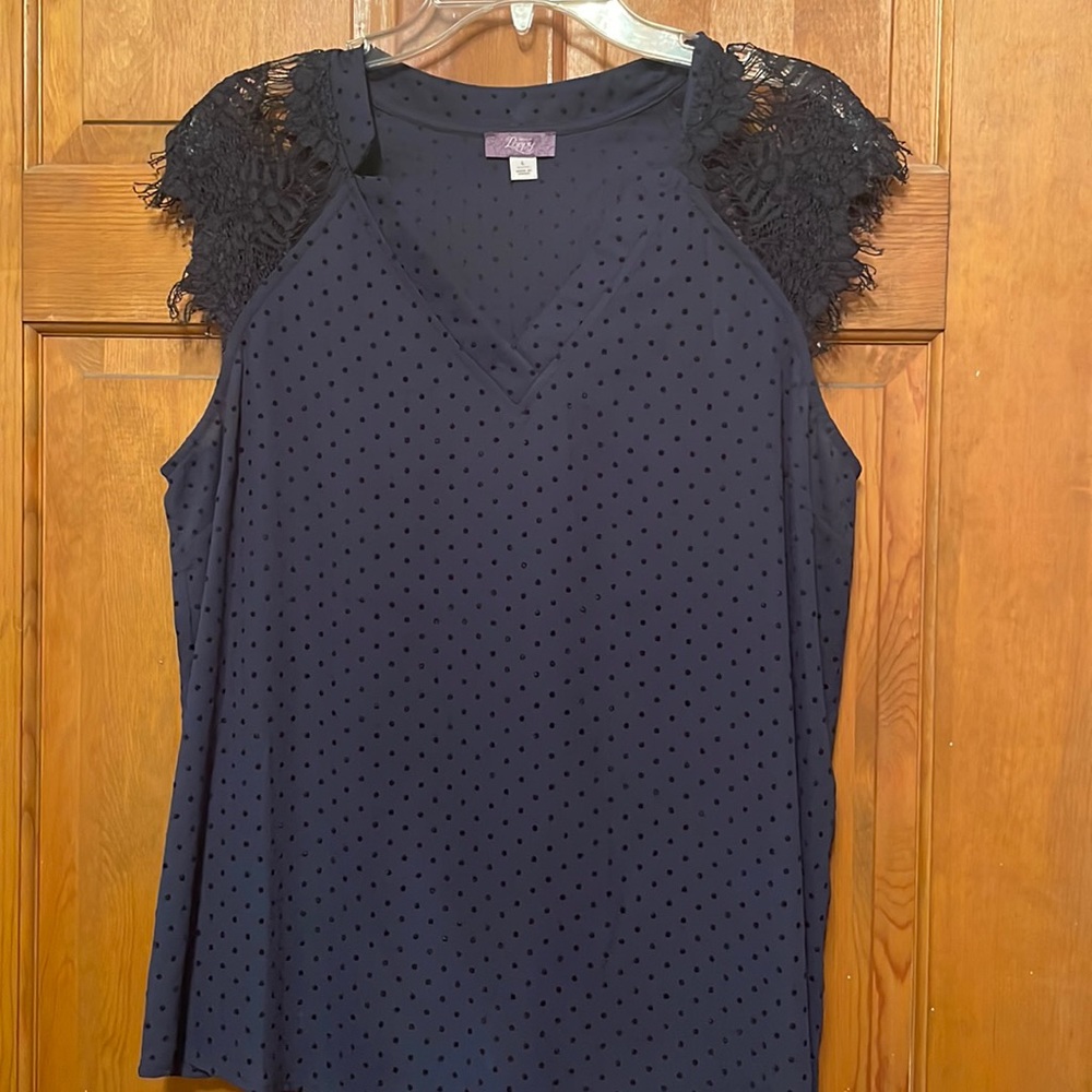 Subtle polka dots and lace cap sleeves make this navy blouse a must-have